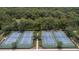 Aerial shot of several beautiful tennis courts with lush green trees and landscaping at 179 Birchmont Dr, Deland, FL 32724