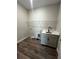Laundry room features stylish wood-look tile, sink, and cabinet at 1881 Sunshine Peak Dr, Minneola, FL 34715