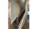 Modern staircase with wood treads, white risers and trim, plus black iron railings at 1881 Sunshine Peak Dr, Minneola, FL 34715