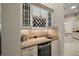 Built-in bar area with granite countertop, wine rack, glass shelving, and a wine cooler at 2204 Baypoint Way, The Villages, FL 32162
