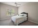 Neutral bedroom with a ceiling fan, neutral carpet, and a window offering views of the outdoors at 2204 Baypoint Way, The Villages, FL 32162