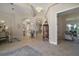 Open hallway featuring tile flooring, archways, and views of the dining and living areas at 2204 Baypoint Way, The Villages, FL 32162