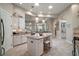 Open kitchen with white cabinets, stainless appliances, granite countertops, and island with seating at 2204 Baypoint Way, The Villages, FL 32162