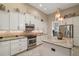 Bright kitchen boasts white cabinets, stainless appliances, granite countertops, and a tile backsplash at 2204 Baypoint Way, The Villages, FL 32162