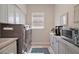 Clean and functional laundry room with appliances, cabinetry, and a window for natural light at 2204 Baypoint Way, The Villages, FL 32162