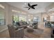 Open-concept living room featuring tile floors, stylish furniture, a ceiling fan, and a sliding glass door at 2204 Baypoint Way, The Villages, FL 32162