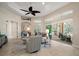 Bright living room with a ceiling fan, tile floors, stylish furniture, and access to the lanai at 2204 Baypoint Way, The Villages, FL 32162