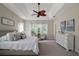Bright main bedroom featuring a tray ceiling, ceiling fan, large windows, and neutral tones at 2204 Baypoint Way, The Villages, FL 32162