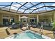 This screened patio features a jacuzzi, lounge chairs, and bar seating for seamless indoor-outdoor living and entertaining at 2204 Baypoint Way, The Villages, FL 32162