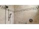 Shower with neutral tile, tile accents, a hand-held shower head, a grab bar, and a control valve at 2204 Baypoint Way, The Villages, FL 32162