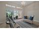 Cozy sunroom with comfortable seating and sliding glass doors leading to the outdoor patio at 2204 Baypoint Way, The Villages, FL 32162