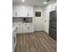 Modern kitchen with white cabinets, stainless steel appliances, and wood-look flooring at 2227 S Spring Garden Ave, Deland, FL 32720