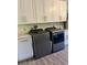 Efficient laundry room with white cabinets, modern washer and dryer units on a wood floor at 2227 S Spring Garden Ave, Deland, FL 32720