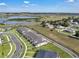 An aerial view showcasing modern townhomes, green spaces, nearby lake, and surrounding community at 2552 Chickasaw Plum Loop, Clermont, FL 34711