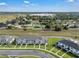 An aerial view showcasing modern townhomes surrounded by green spaces and mature trees at 2552 Chickasaw Plum Loop, Clermont, FL 34711