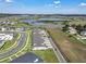 An aerial view showcasing modern townhomes, green spaces, nearby lake, and surrounding community at 2552 Chickasaw Plum Loop, Clermont, FL 34711