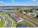 Aerial view of a modern townhome community near a lake and highway, indicated by a location pin at 2552 Chickasaw Plum Loop, Clermont, FL 34711