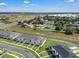An aerial view showcasing modern townhomes surrounded by green spaces and mature trees at 2552 Chickasaw Plum Loop, Clermont, FL 34711