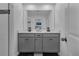 Modern bathroom featuring double sinks, gray cabinetry, and a neutral color palette at 2552 Chickasaw Plum Loop, Clermont, FL 34711