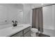 Clean bathroom featuring a gray vanity, tub, and shower with gray curtain and modern fixtures at 2552 Chickasaw Plum Loop, Clermont, FL 34711