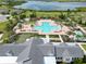 Aerial view of the community pool and clubhouse featuring a vibrant swimming pool, lounge area, and scenic water view at 2552 Chickasaw Plum Loop, Clermont, FL 34711