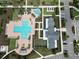 Aerial view of a community pool, splash pad, lounge chairs, and lush landscaping creating a resort-style oasis at 2552 Chickasaw Plum Loop, Clermont, FL 34711