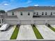 Exterior view of townhomes, with driveways and landscaping at 2552 Chickasaw Plum Loop, Clermont, FL 34711