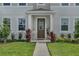 Inviting townhome entrance with lush landscaping, a covered porch, and a modern front door at 2552 Chickasaw Plum Loop, Clermont, FL 34711