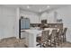 Modern kitchen with white cabinetry, a center island with bar stools, and stainless steel appliances at 2552 Chickasaw Plum Loop, Clermont, FL 34711