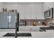 Close-up of a modern kitchen featuring stainless steel appliances and sleek white countertops at 2552 Chickasaw Plum Loop, Clermont, FL 34711