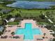 Aerial image of the community pool, surrounded by a lake and lush landscaping at 2552 Chickasaw Plum Loop, Clermont, FL 34711