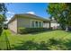 Backyard view featuring mature landscaping, healthy green lawn, and the home's exterior at 2602 Stargrass Cir, Clermont, FL 34715
