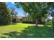 Expansive backyard featuring a lush lawn, mature trees, and views of the home's screened-in lanai at 2602 Stargrass Cir, Clermont, FL 34715
