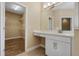 Bathroom with a vanity, mirror, and a doorway leading to a walk-in closet at 2602 Stargrass Cir, Clermont, FL 34715