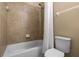 Bathtub and shower combo with tile surround, paired with a toilet and sink at 2602 Stargrass Cir, Clermont, FL 34715