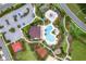 Aerial view of the community showcasing a pool, playground, parking, and recreational areas surrounded by lush landscaping at 2602 Stargrass Cir, Clermont, FL 34715