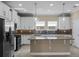 Bright kitchen boasts stainless steel appliances, white cabinets, and an island with hanging lights at 2602 Stargrass Cir, Clermont, FL 34715