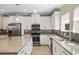 Modern kitchen with stainless steel appliances, mosaic tile backsplash, and granite countertops at 2602 Stargrass Cir, Clermont, FL 34715