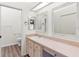 Bright bathroom features a long vanity with double sinks and framed mirrors at 26030 Newcombe Cir, Leesburg, FL 34748