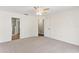 Spacious bedroom with neutral carpet, a ceiling fan, and a walk-in closet for ample storage at 26030 Newcombe Cir, Leesburg, FL 34748