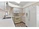 Kitchen featuring white cabinets, appliances, and countertop with a skylight at 26030 Newcombe Cir, Leesburg, FL 34748