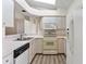 Kitchen featuring white appliances, white cabinetry, and skylight above at 26030 Newcombe Cir, Leesburg, FL 34748
