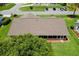 Aerial view of the home showcasing the roof, landscaping, and surrounding greenery at 26608 Racquet Cir, Leesburg, FL 34748