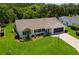 Inviting single-story home with well-manicured lawn, tasteful landscaping, and brick-paved driveway at 26608 Racquet Cir, Leesburg, FL 34748