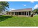 Scenic backyard featuring a lush green lawn and covered lanai at 26608 Racquet Cir, Leesburg, FL 34748