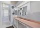 Bathroom with sink, large mirror, and shower with shower curtain and window at 26608 Racquet Cir, Leesburg, FL 34748