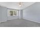 Calm primary bedroom featuring a ceiling fan and window overlooking green outdoor space at 26608 Racquet Cir, Leesburg, FL 34748