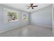 Serene bedroom featuring large windows, tile floors, and neutral paint tones at 26608 Racquet Cir, Leesburg, FL 34748