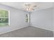 Bedroom with carpet, ceiling fan, and view of the lawn through the window at 26608 Racquet Cir, Leesburg, FL 34748