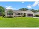 Charming single-story home boasts lush landscaping, a screened garage, and a beautifully maintained lawn at 26608 Racquet Cir, Leesburg, FL 34748